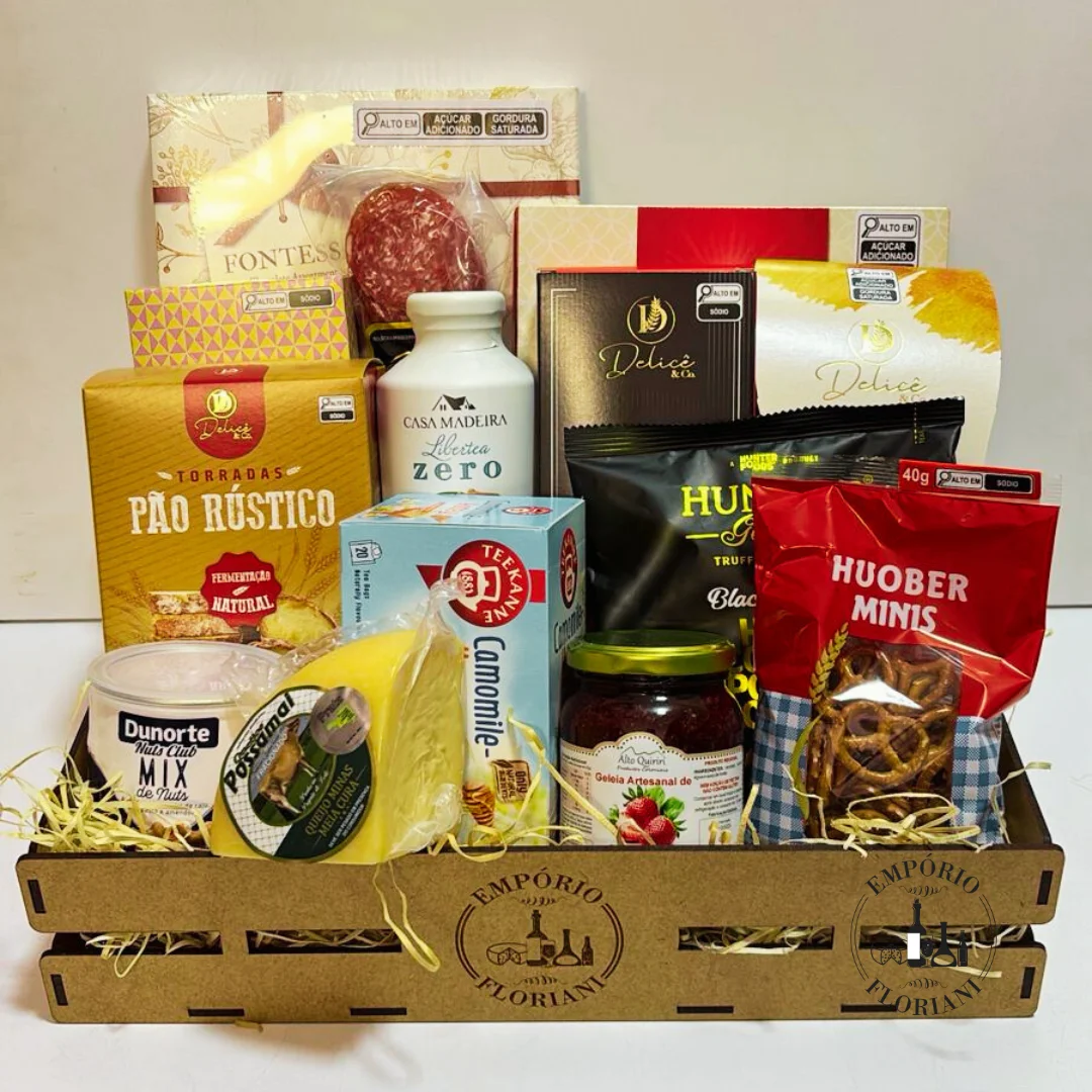 Cesta com bolo decorado, uvas, pães de queijo e cappuccino