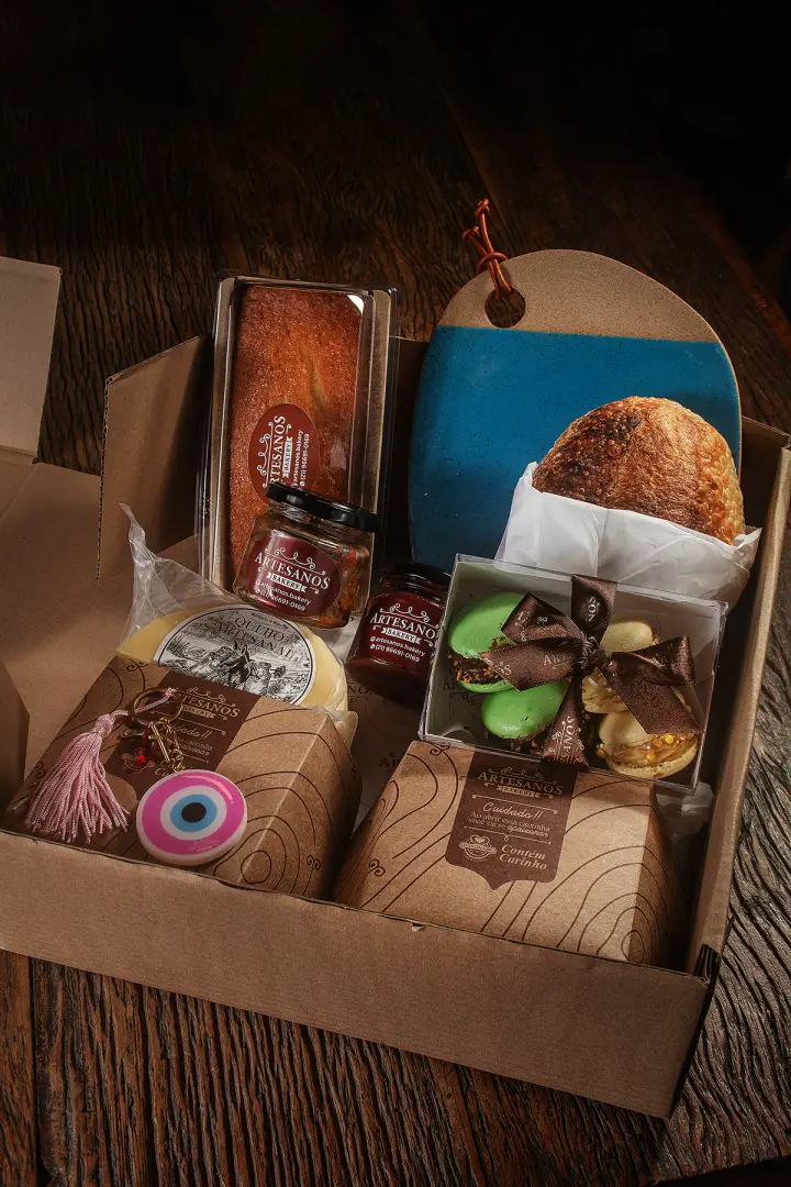 Cesta gourmet com pães, suco, frios e acompanhamentos
